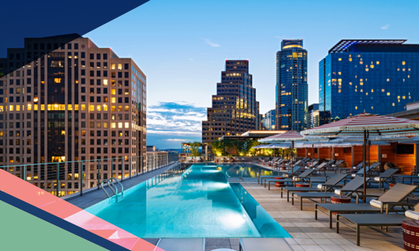 Rooftop pool area of the Austin Marriott Downtown, featuring umbrellas, loungers and city skyline views