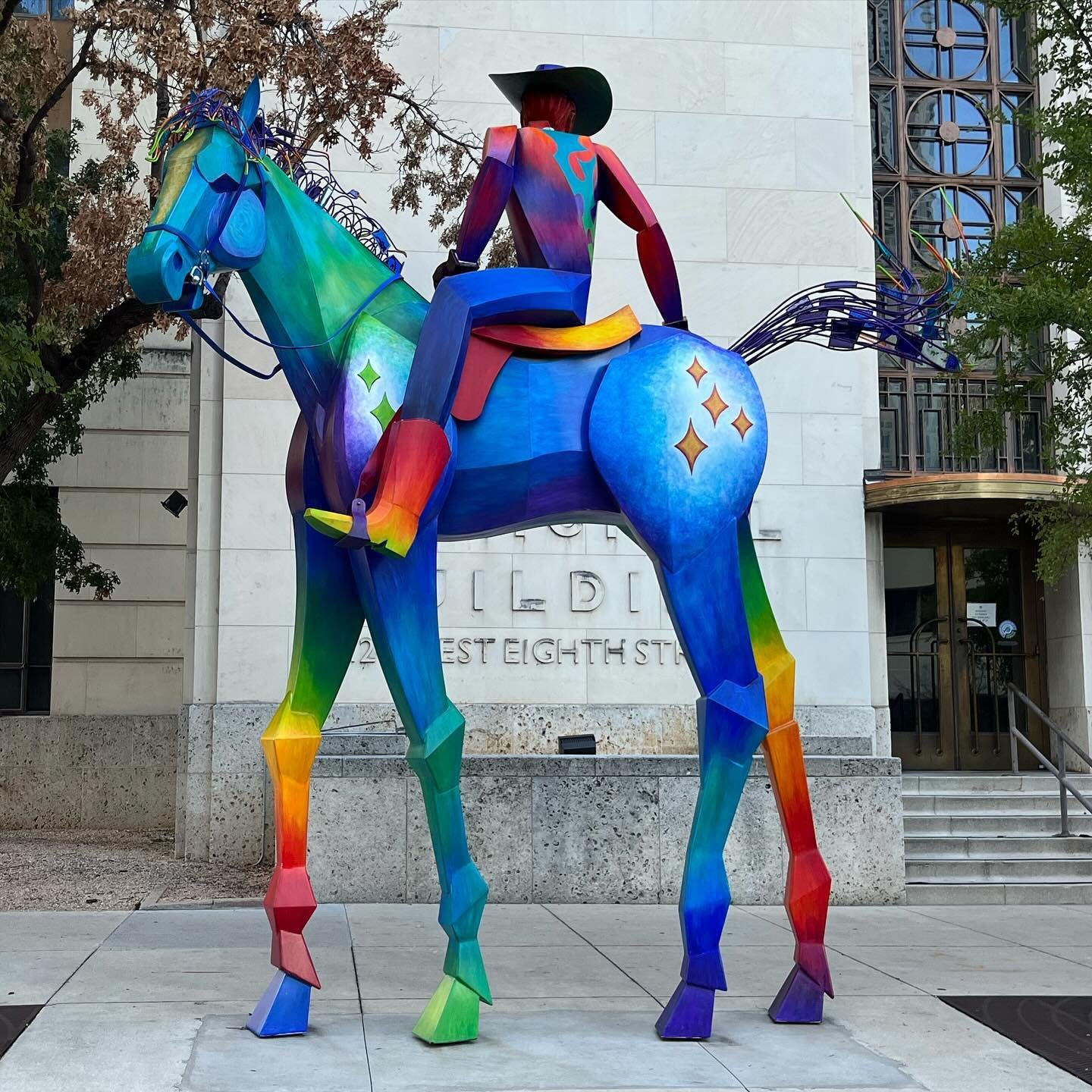 Tracking the End of the Rainbow, a neon rainbow-colored sculpture of a man on a horse in downtown Austin, Texas