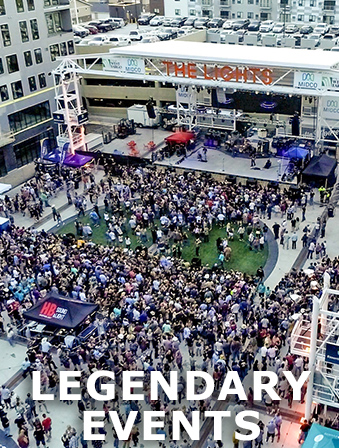 Aerial view of a crowd at an outdoor concert in North Dakota, with overlay text that reads: Legendary Events