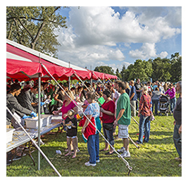 Crowd of people waiting to purchase things at tents set up at an outdoor event in North Dakota