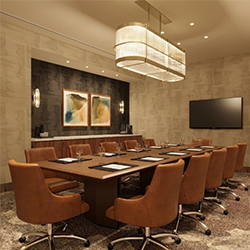 Conference room with a wooden table and brown leather office chairs at Hotel Trinity, Autograph Collection in Austin, Texas