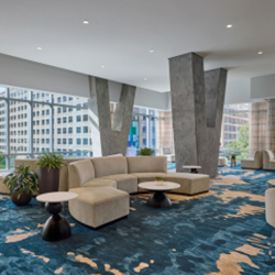 Contemporary lounge area with a sectional sofa, chairs, tables and V-shaped support pillars inside the JW Marriott Austin
