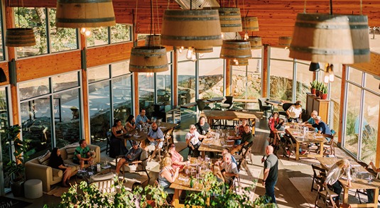 Tasting room with wraparound windows and wine barrel-shaped chandeliers at William Chris Vineyards near Austin, Texas
