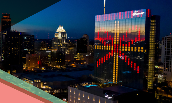 Light display on the glass facade of the Fairmont Austin hotel and the Downtown Austin skyline
