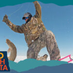 Man pulling a fish out of a hole in ice, with overlay text that reads: Hello North Dakota