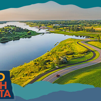 Aerial view of a river, green landscapes and a winding road, with overlay text that reads: Hello North Dakota