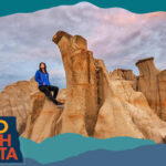 Woman sitting on tall, tan rock formations, with overlay text that reads: Hello North Dakota