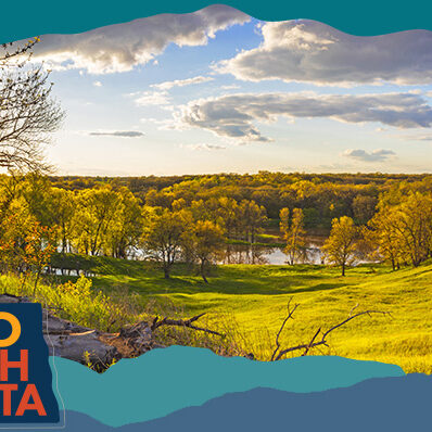Scenic landscape of a hilly valley with orange and yellow trees of fall in the distance, with overlay text that reads: Hello North Dakota