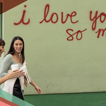 Two women walk by the i love you so much mural in Austin. Texas