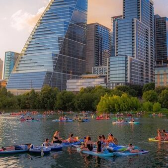 Kayakers on Lady Bird Lake with downtown Austin skyscrapers in the background