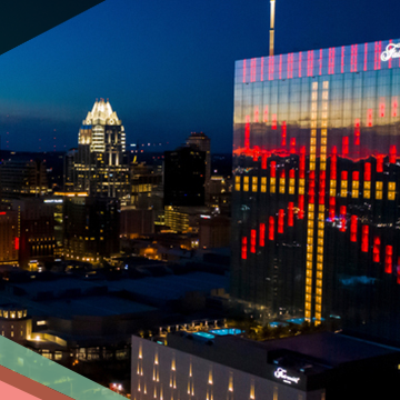 Light display on the glass facade of the Fairmont Austin hotel and the Downtown Austin skyline